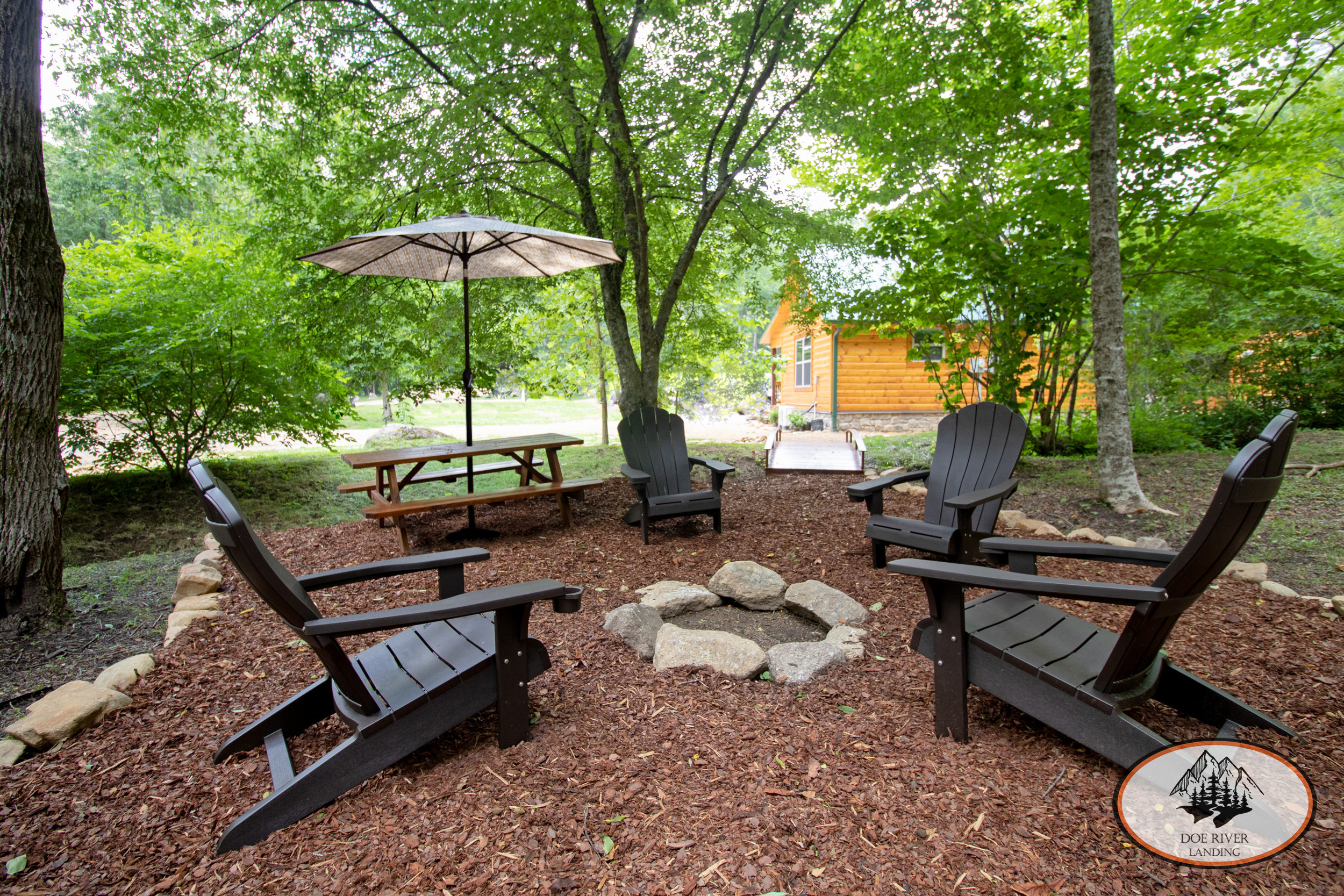 Doe River Landing campground in Roan Mountain, TN. Best vacation rental near Elizabethton, TN and Johnson City TN. Brown Trout Cabin private riverside campsite with fire pit, picnic table, grill, and umbrella.