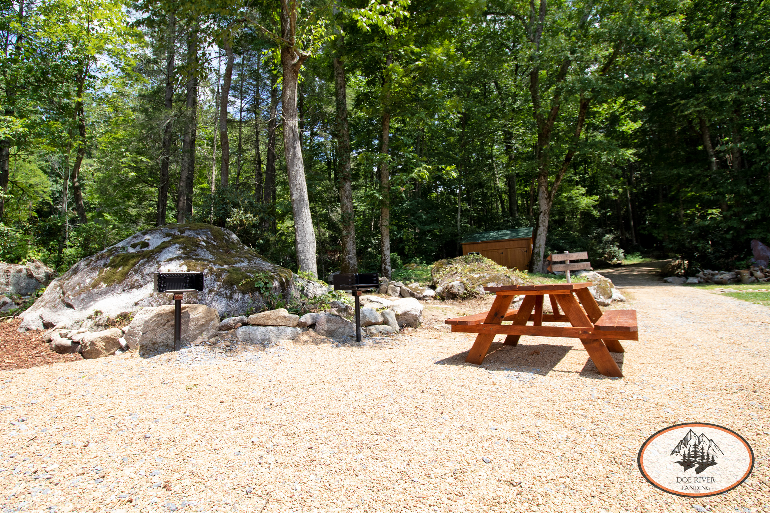 Doe River Landing campground and event venue in Roan Mountain, TN. Best vacation rental and event space near Elizabethton, TN and Johnson City TN. The Water's Edge Pavilion riverside campsite with fire pit, picnic table, grill, and umbrella.